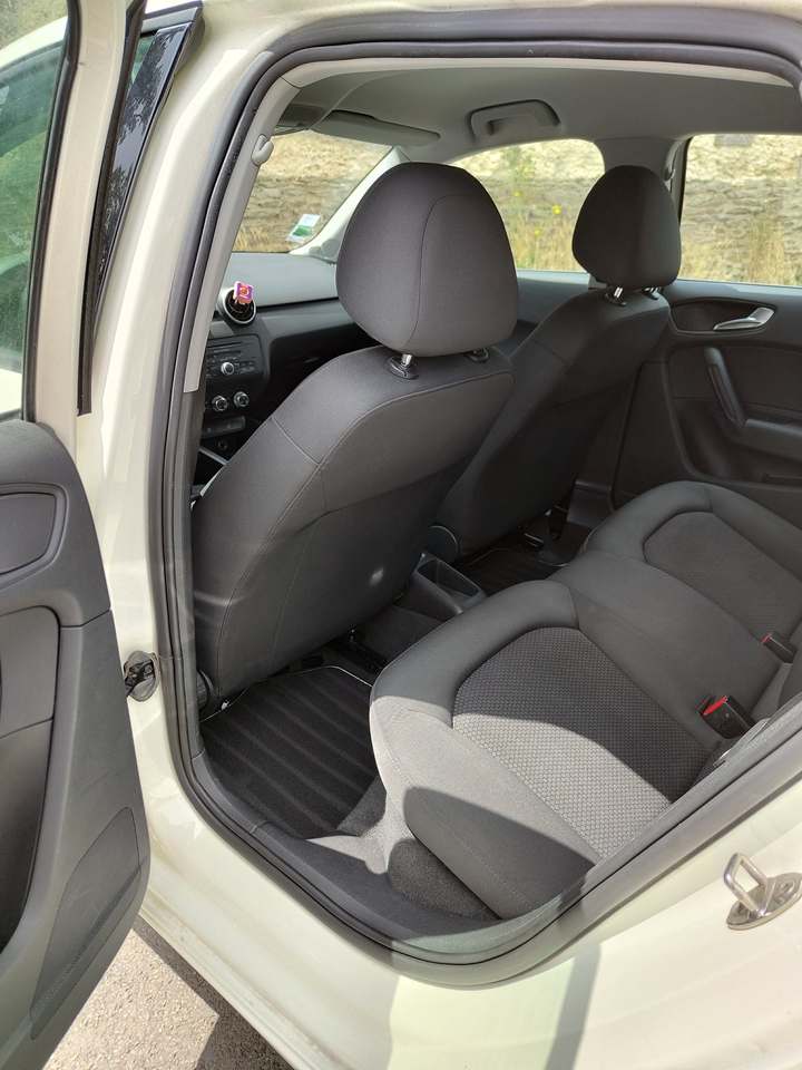 Banquette arrière en tissu et tapis d’une Audi A1, portière ouverte