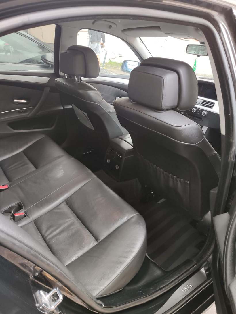 Sellerie cuir noire de la banquette arrière d’une BMW Série 5, portière ouverte