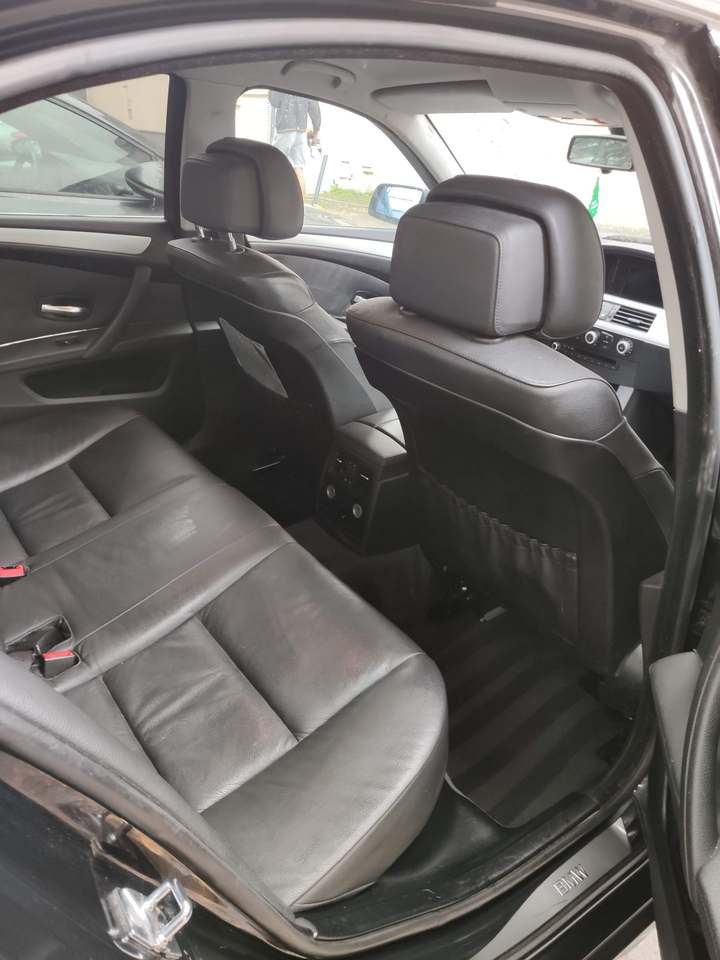 Sellerie cuir noire de la banquette arrière d’une BMW Série 5, portière ouverte