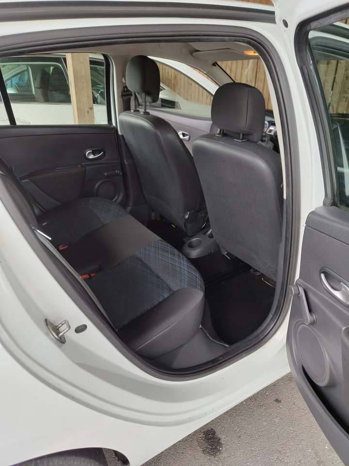 Banquette arrière et tapis d’une Renault Clio III blanche, portière ouverte